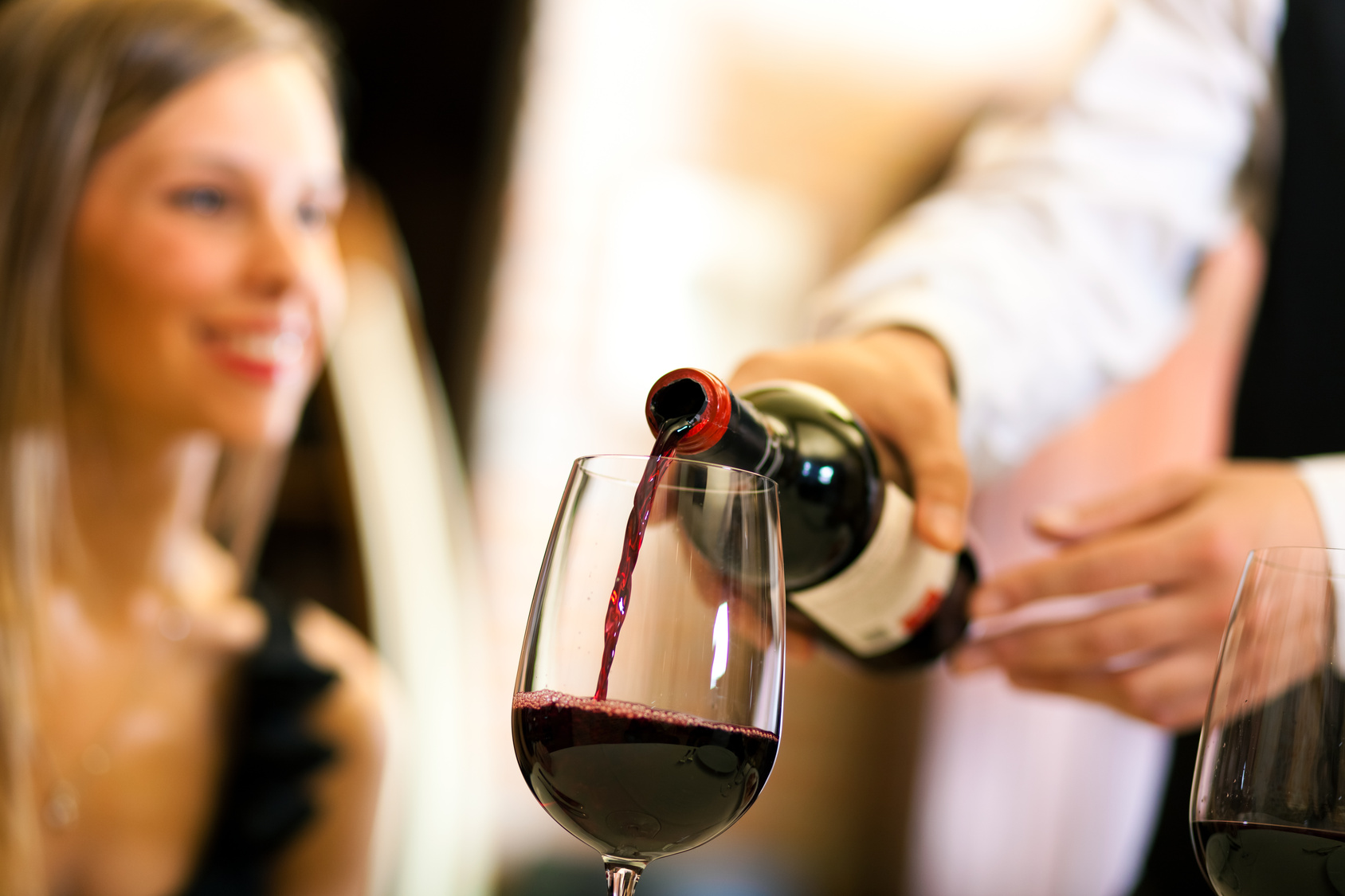 Waiter serving red wine