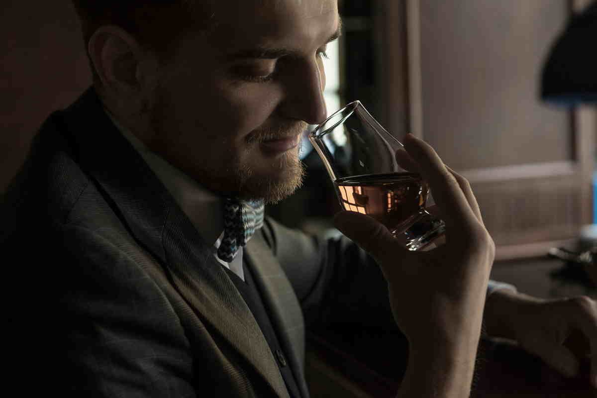 Uomo sente aroma del whisky